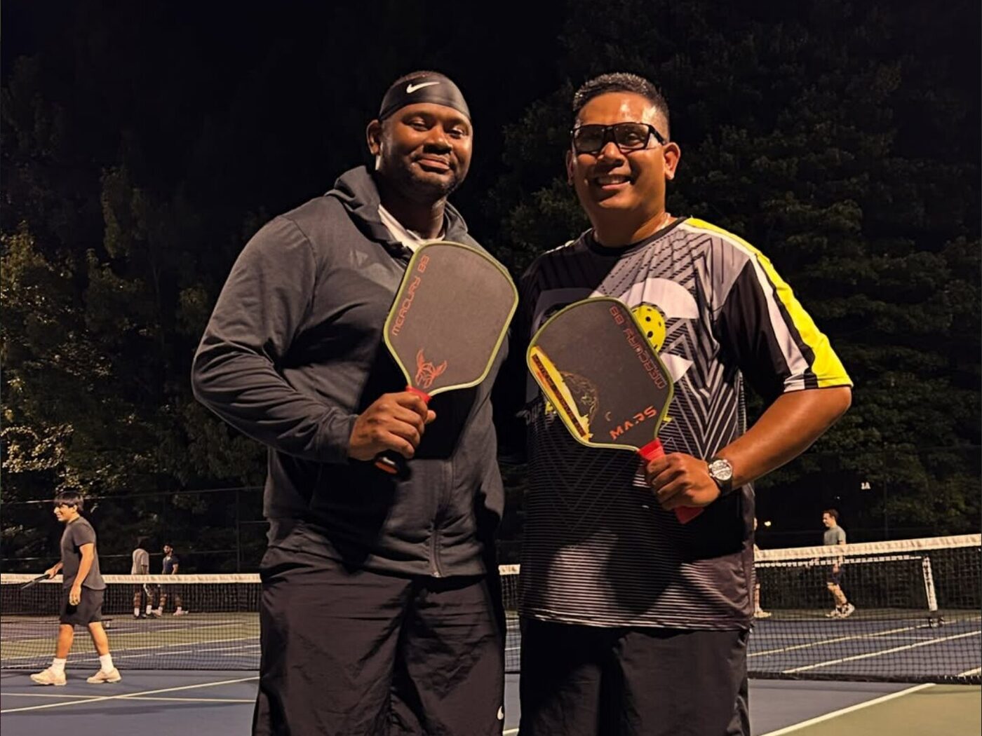 Coach Ronnie with a fellow player, both holding Mars paddles